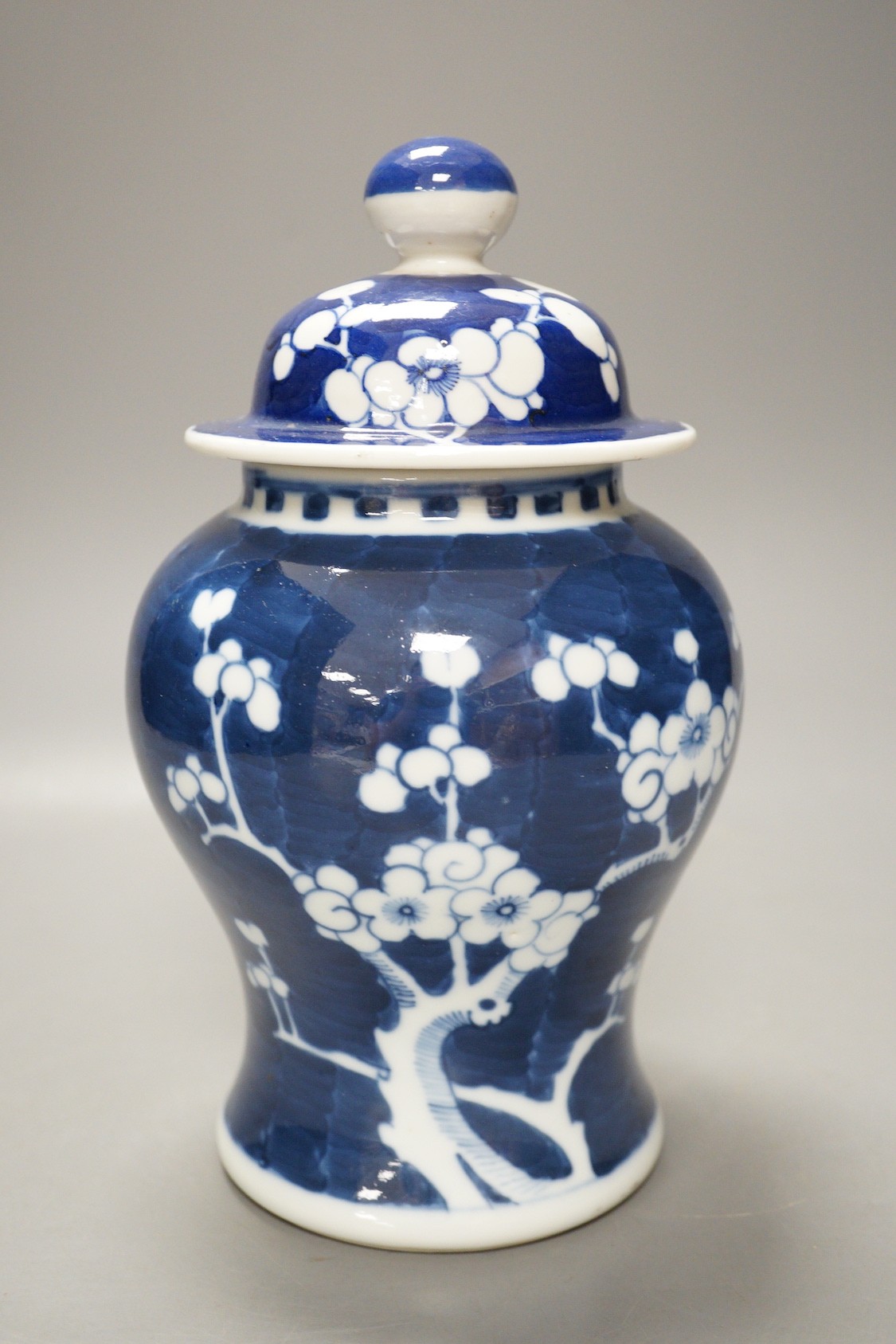 An early 20th century Chinese blue and white prunus vase and cover, 23cm